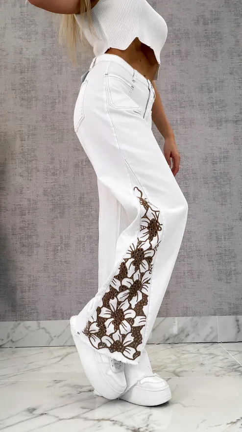 Modne białe elastyczne jeansy dzwony z haftowanymi kwiatami - R609
